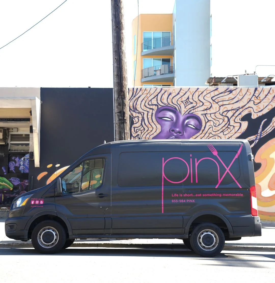 The Pinx Catering delivery van parked in front of a painted street mural